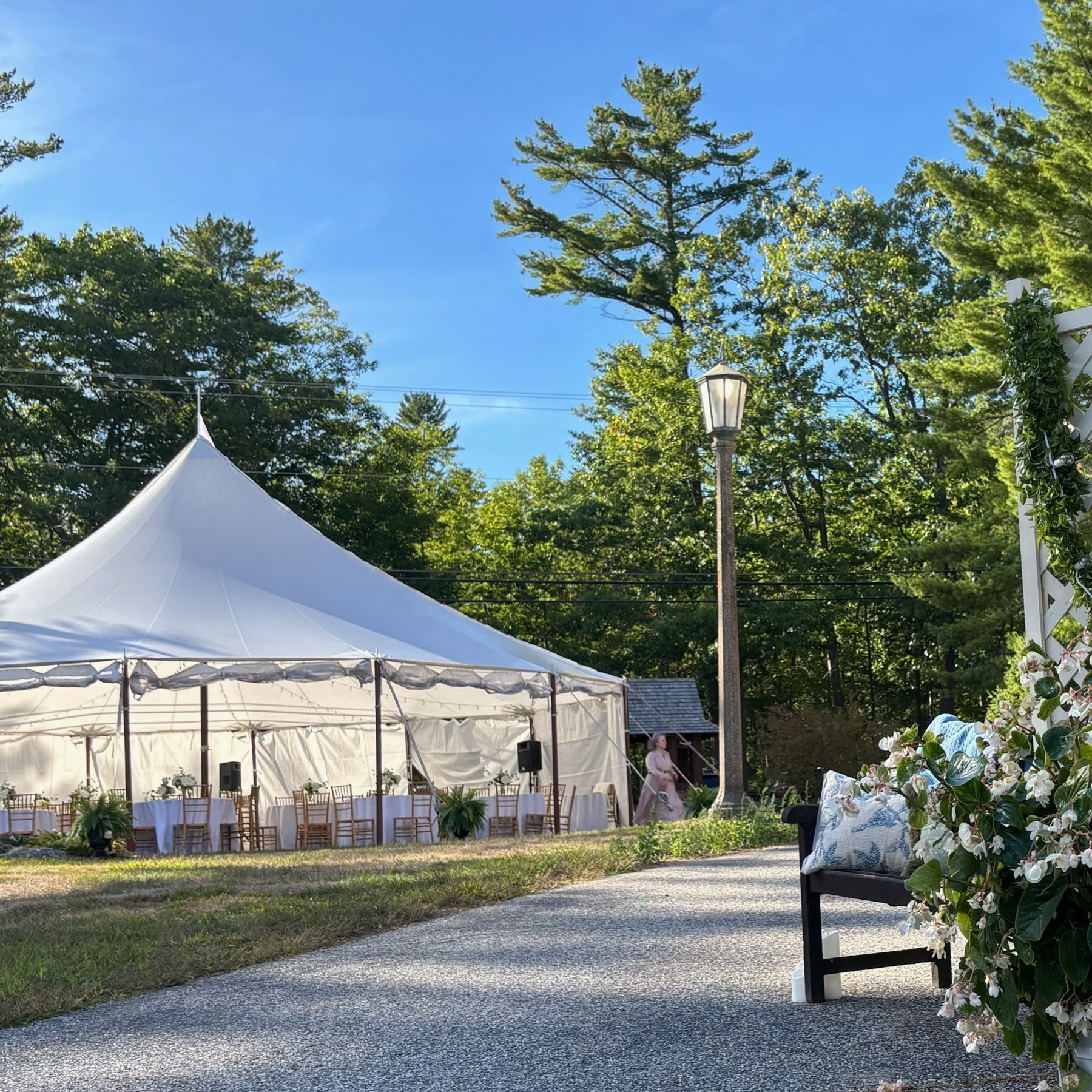 White reception tent seen along a garden path