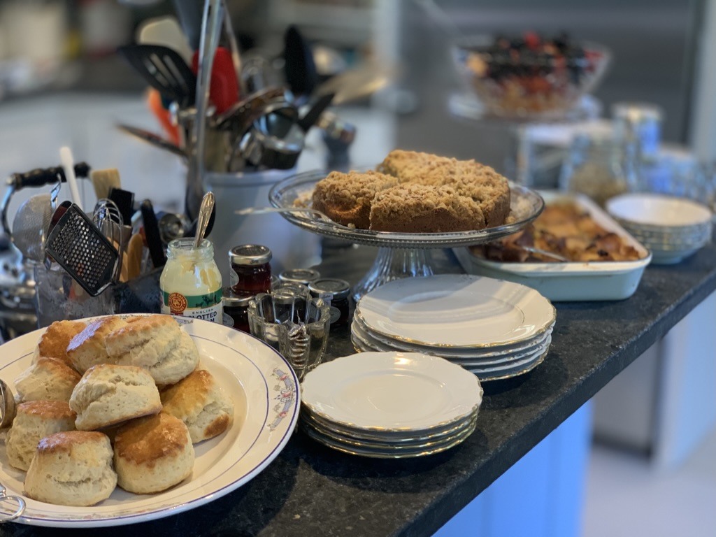Scones, cake, fruit and stacked plates arranged for a breakfast buffet