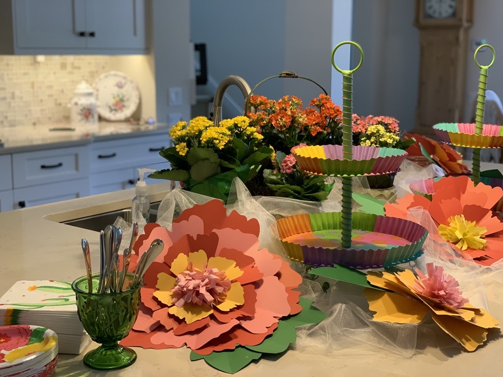 Colorful paper flowers and tiered stands arranged across a kitchen island