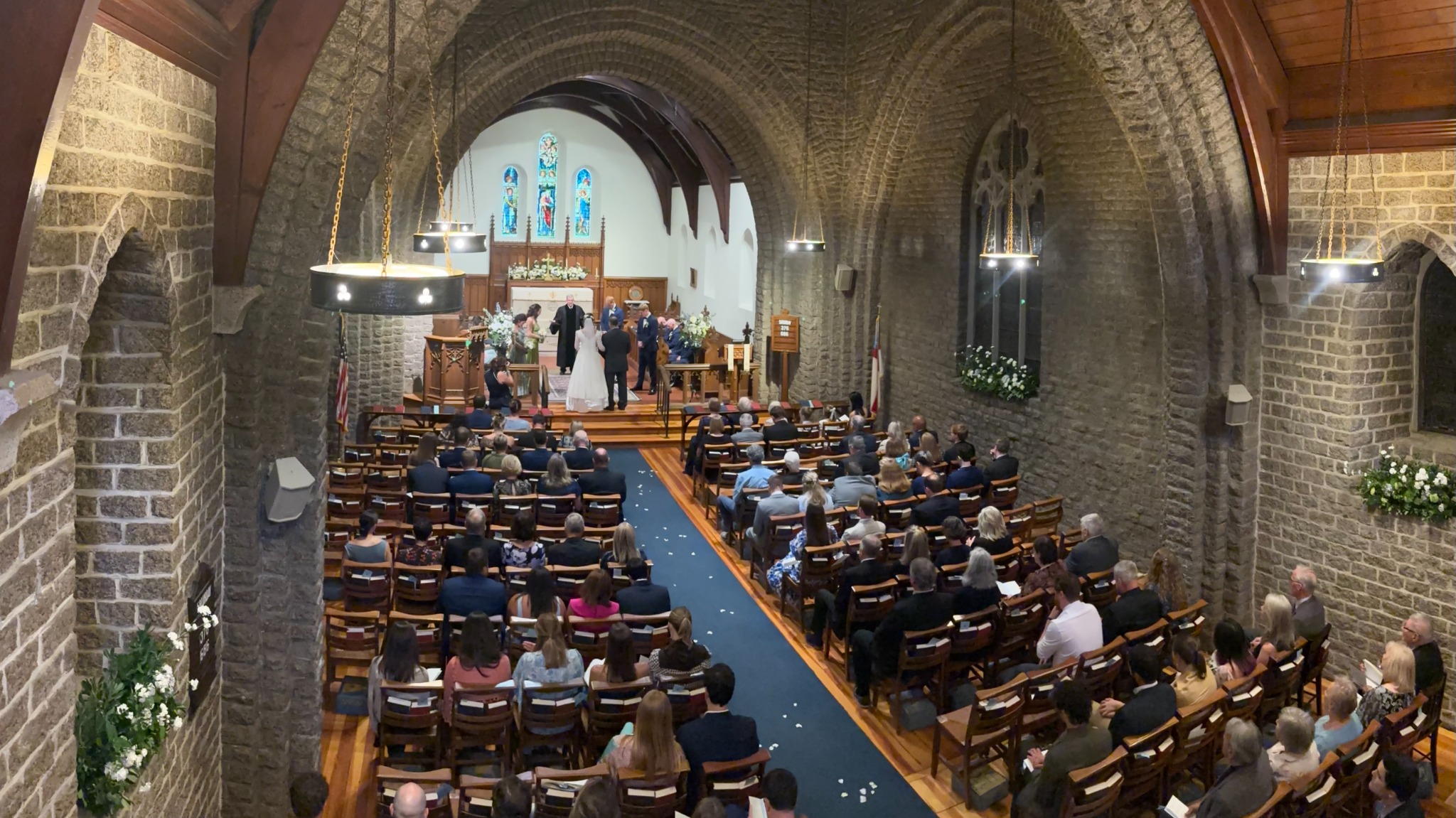 Wide balcony view of the wedding ceremony and guests in St. Mary’s stone church