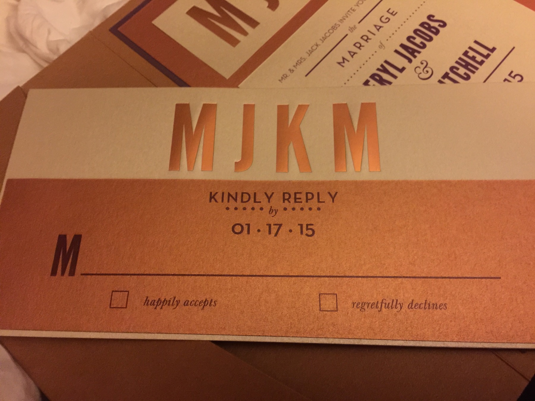 An orange and cream invitation suite with monogrammed reply cards