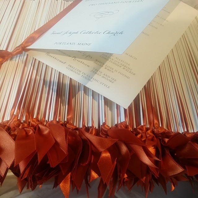 Wedding programs finished with warm orange ribbons