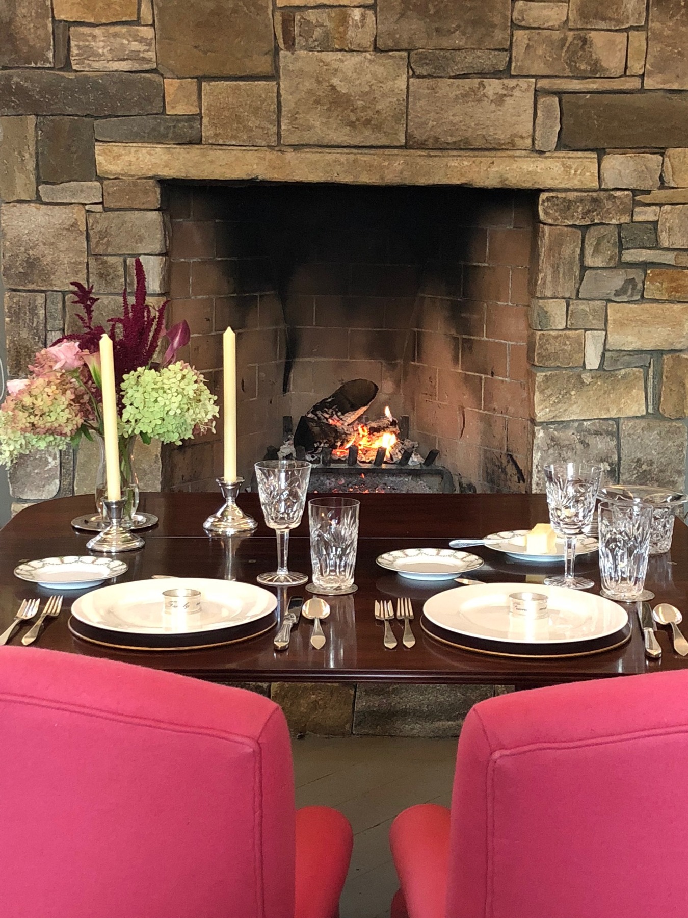 A welcoming dinner table beside a stone fireplace