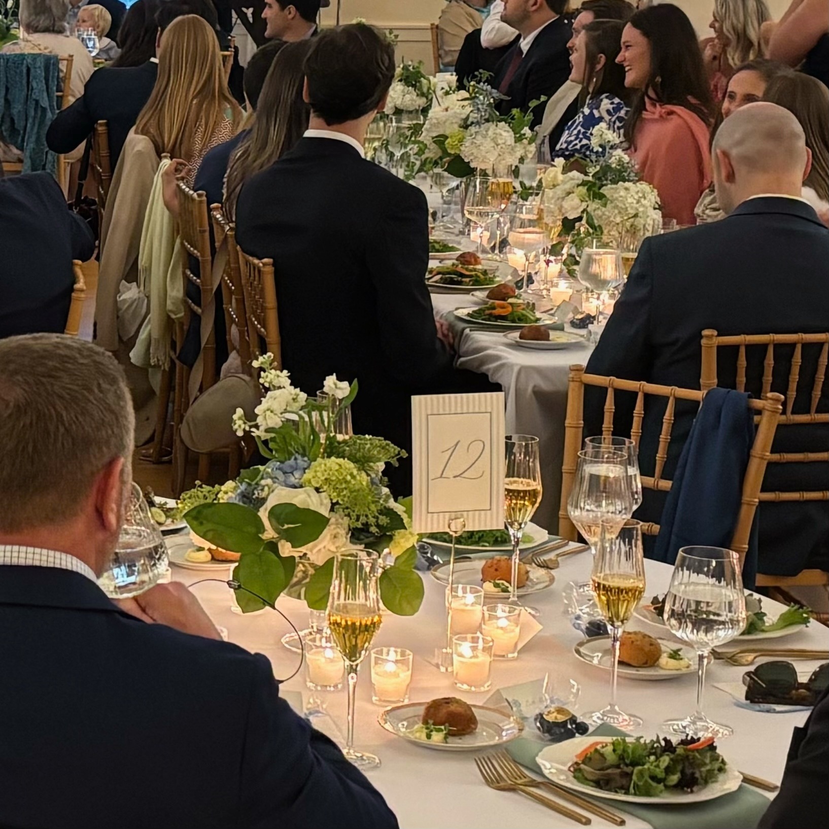 Guests gathered at a wedding reception with flowers and candlelight